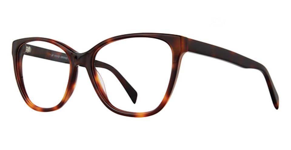 A pair of Vivid Grand 7501 tortoiseshell eyeglasses with a slightly cat-eye shape and thick, high-quality plastic frames. The predominantly dark brown frames with lighter brown flecks create a mottled appearance, while the straight temples match this stylish and comfortable design.
