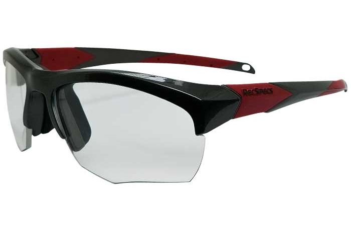 The RecSpecs Impact features clear lenses, a black frame, and red accents on the temples. The frame has a sleek, angular design, and the temples feature the brand logo "Rec Specs." The glasses appear sturdy and designed for active use.