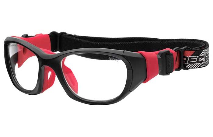 A pair of black sports goggles with clear lenses and red accents. The RecSpecs RS-51 by RecSpecs feature a thick, adjustable black strap with a red and white design on one end. The nose and side cushions are also red for added comfort and protection.