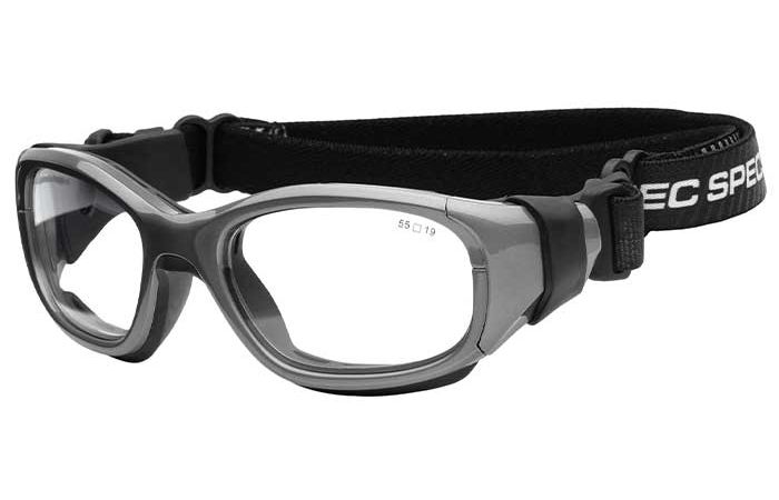 A pair of RecSpecs Slam Goggle XL with clear lenses, a grey and black frame, and an adjustable elastic strap with the text "SPECS SHIELD" in white. The goggles are designed for eye protection during sporting activities.